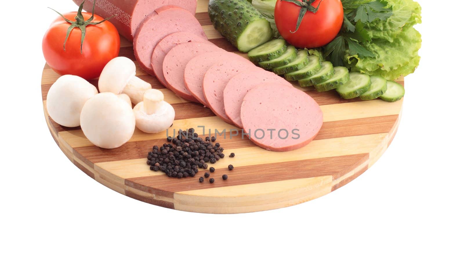 Sliced sausage , butter and vegetables on a wooden plate