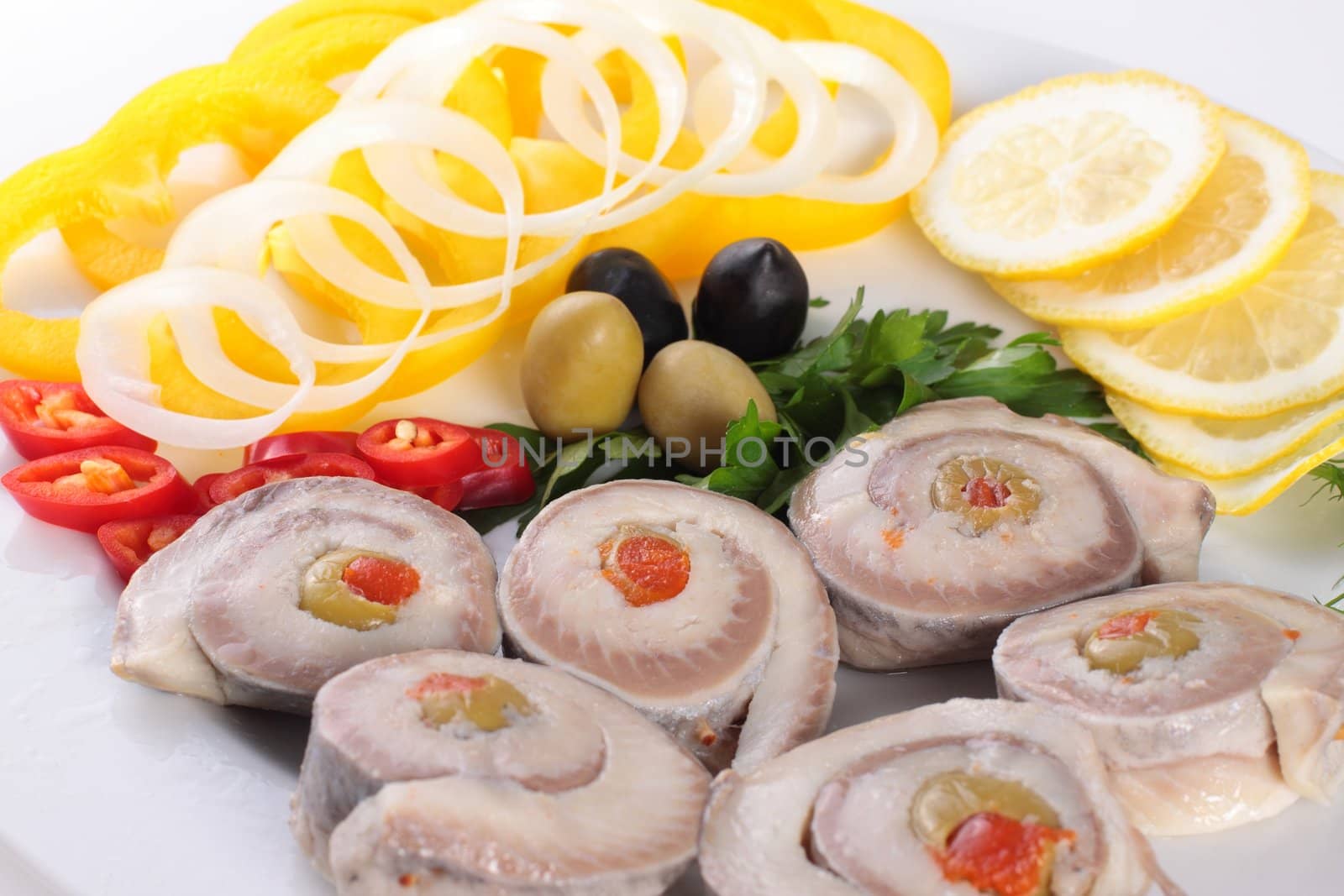 fish with vegetables and olives isolated on white