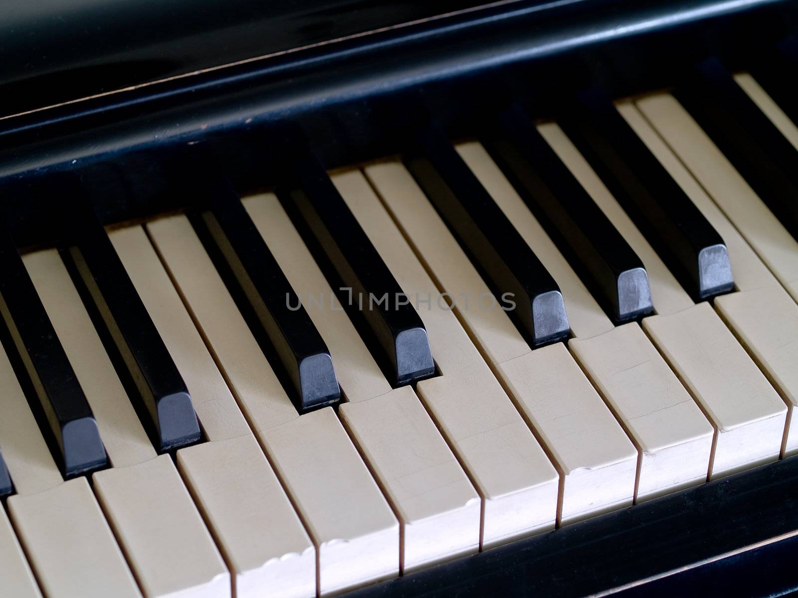 Piano keys of a very well loved and often played piano showing some wear and cracking.