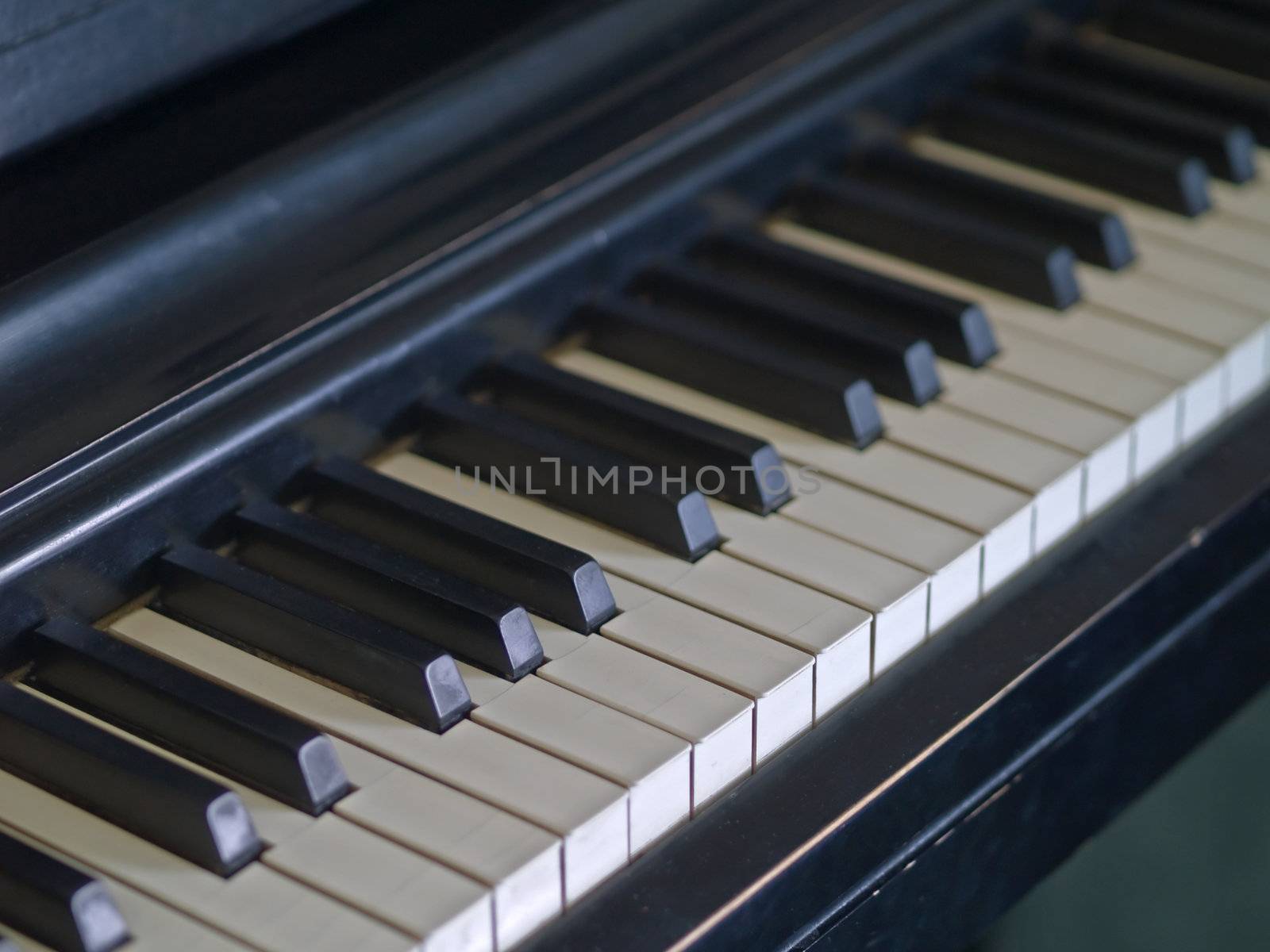 Piano keys of a very well loved and often played piano showing some wear and cracking.