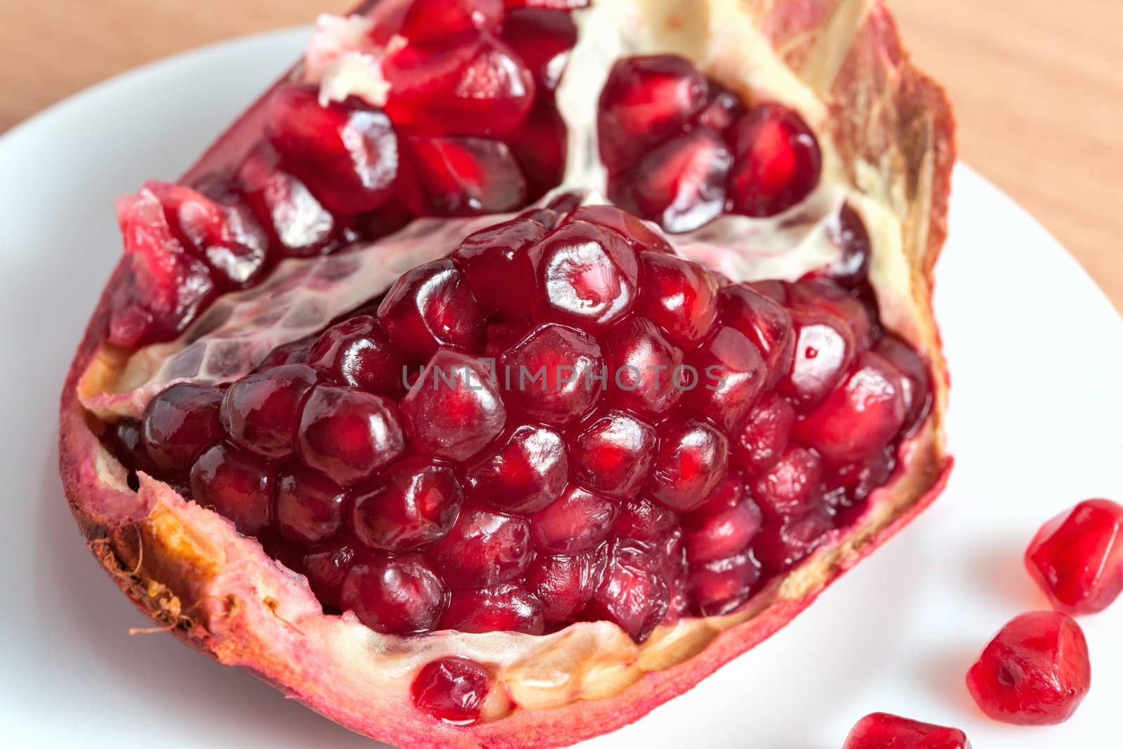 The cut pomegranate and grains on a plate