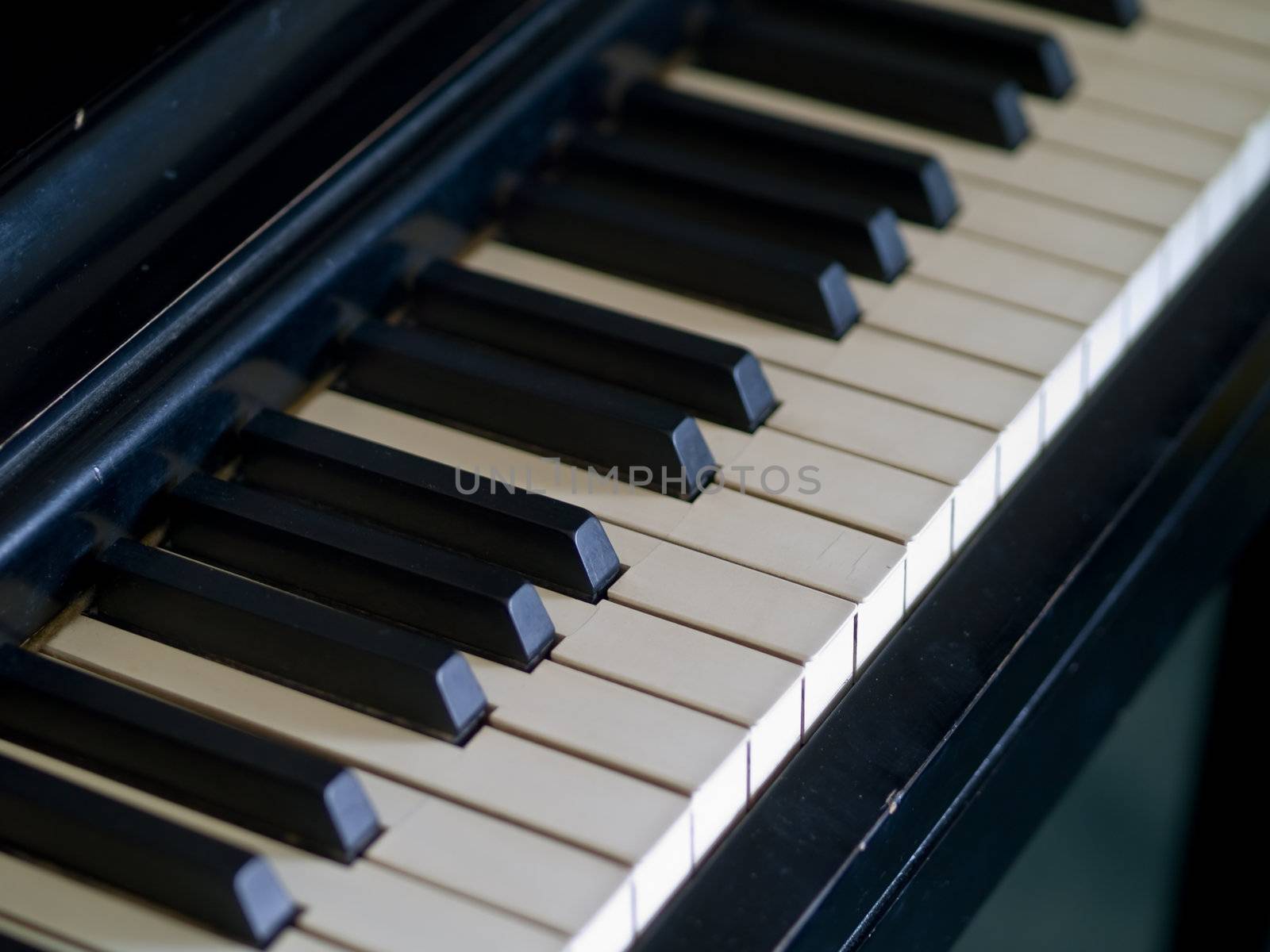 Piano keys of a very well loved and often played piano 