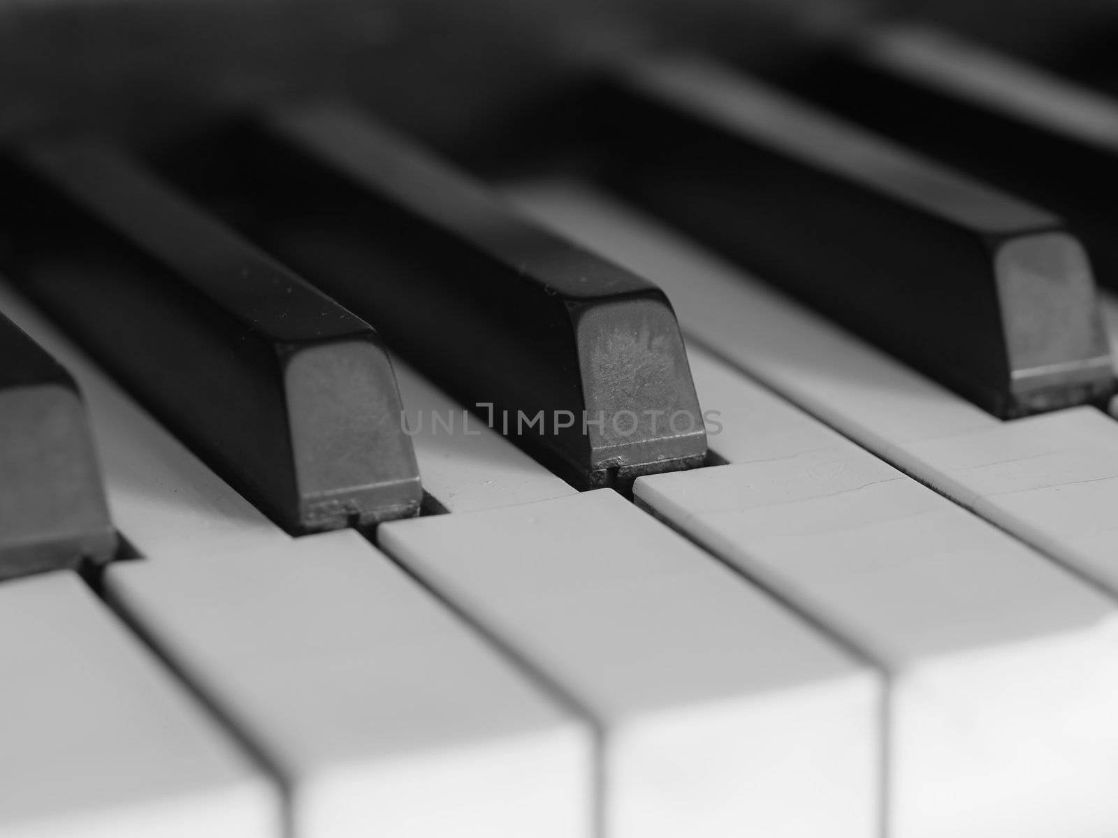 Piano keys of a very well loved and often played piano in monochrome Black and Whit