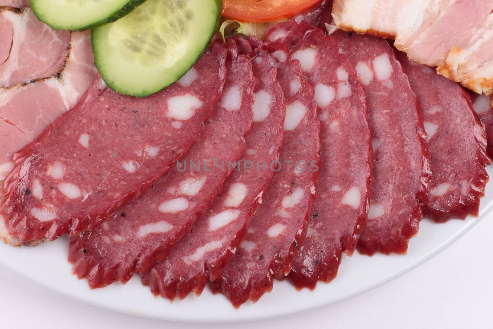 various sliced sausages with vegetables close up
