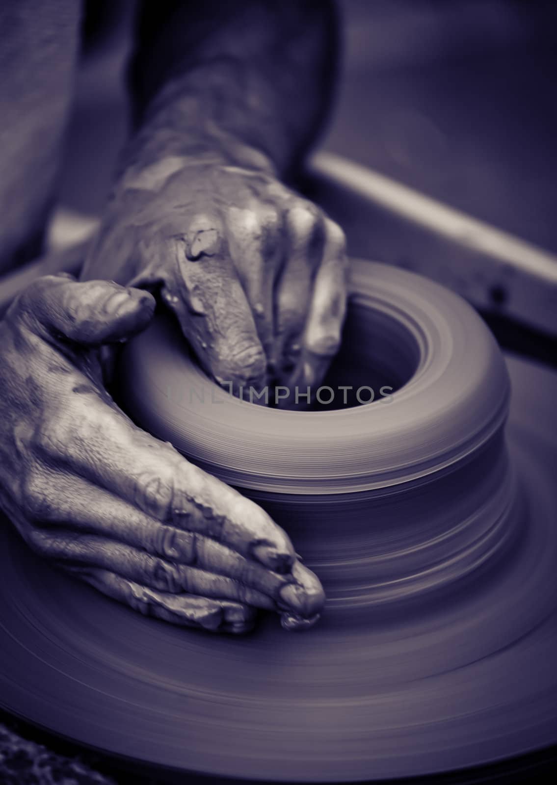 Old man hands working on pottery wheel  by Lizard