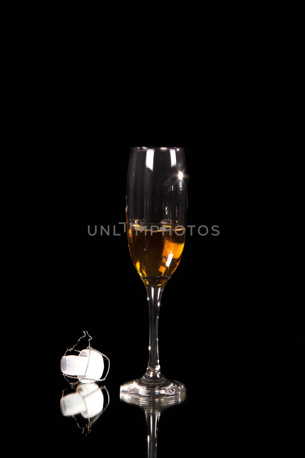 champagne glass with plastic corn isolated on black