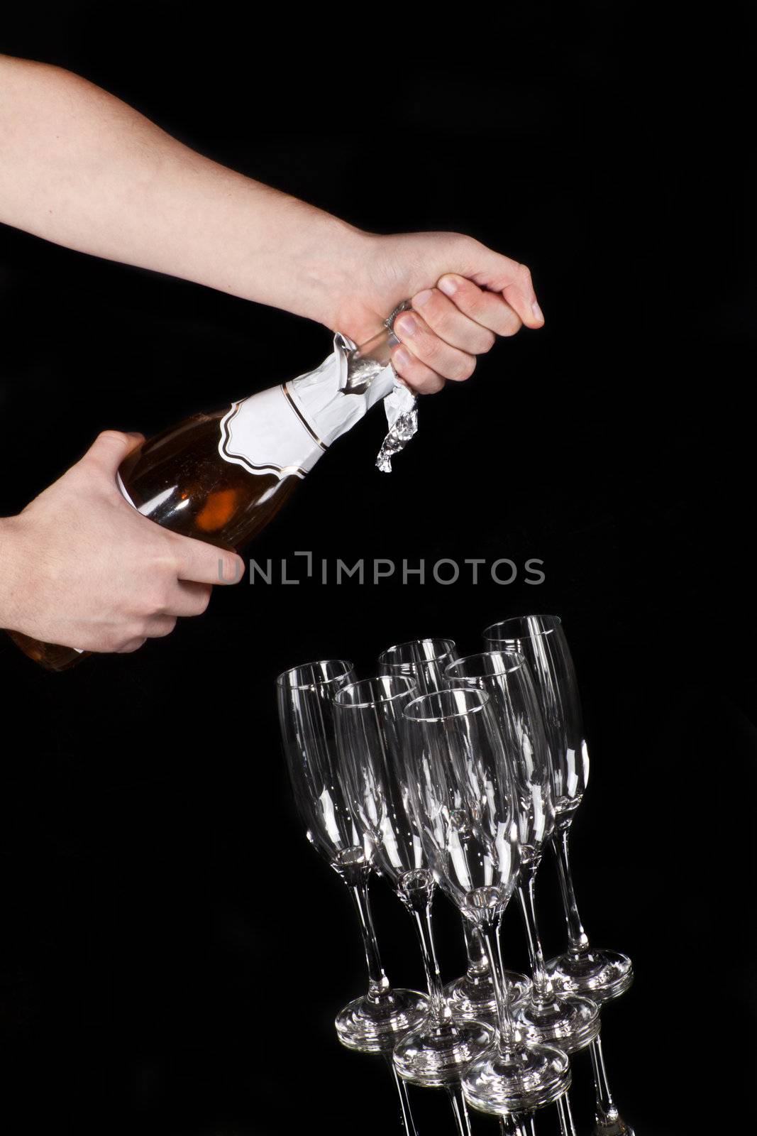 hands opening champagne bottle isolated on black