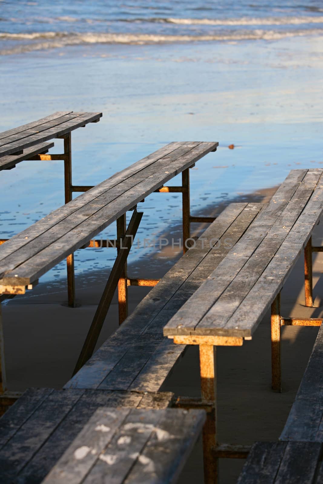 The image of wooden benches on a beach