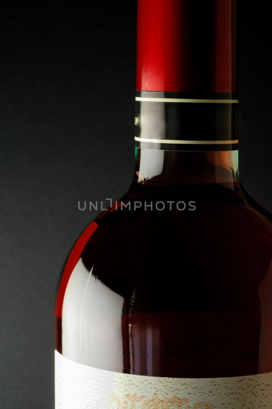 Red wine bottle closeup with red capsule (closeup)
