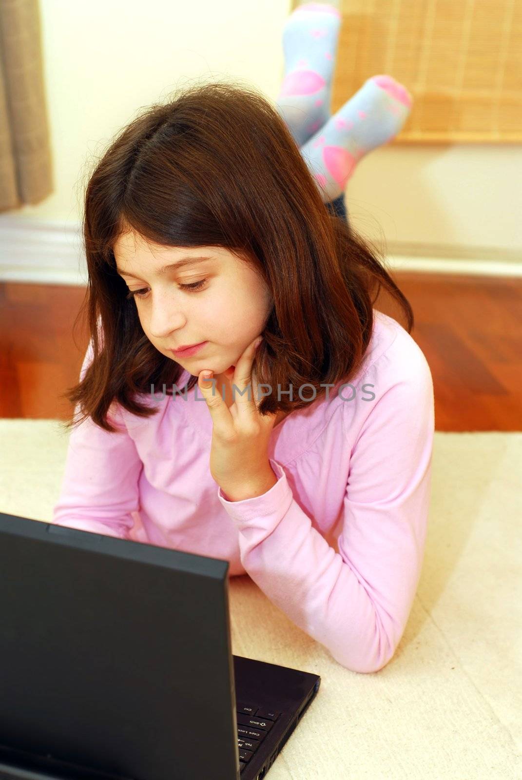 Young girl lying on the floor with portable computer