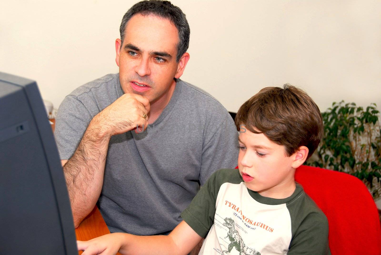 Father teaching his son to work on a computer