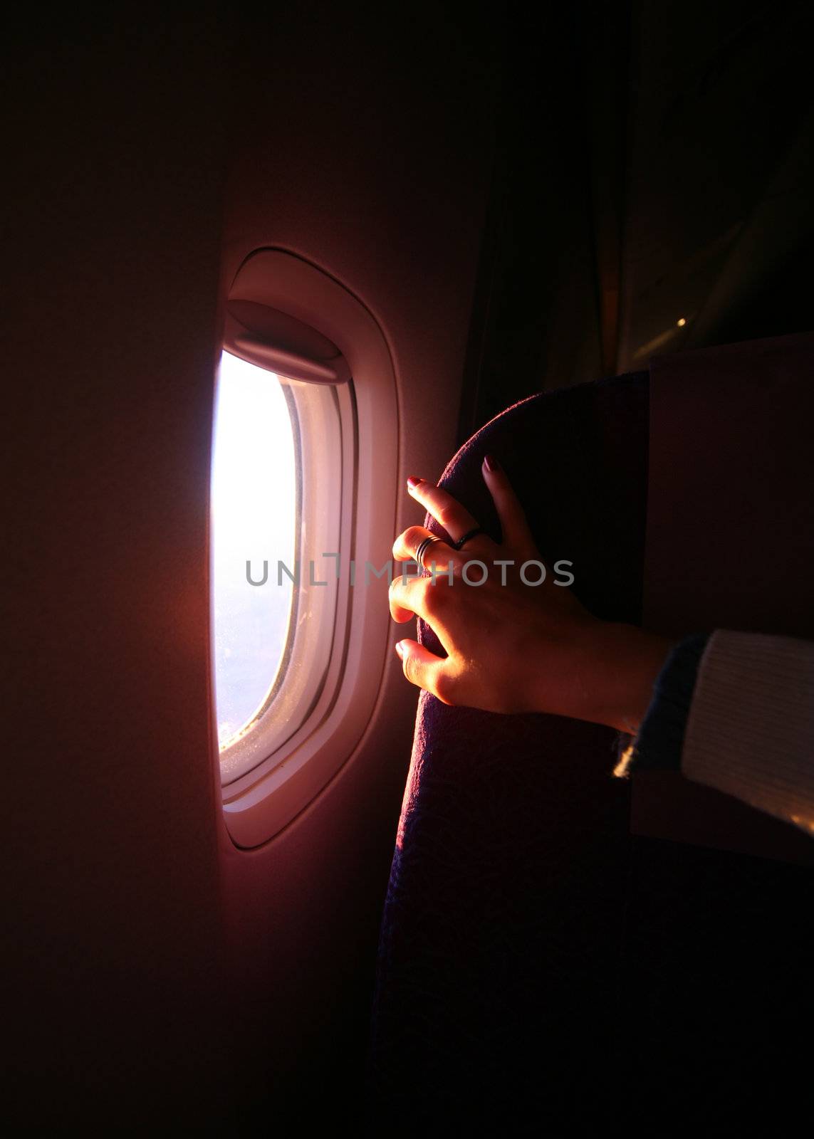 Window of the plane and female hand