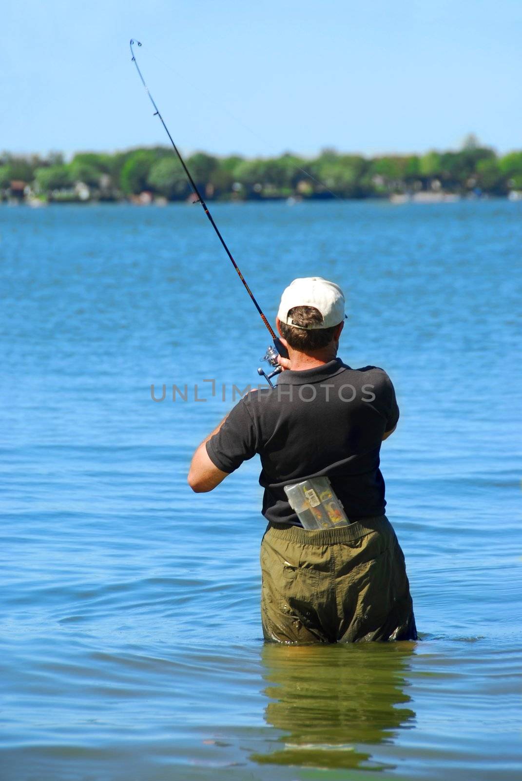 Man fishing in a lake standing in water