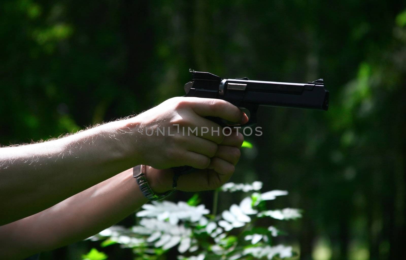 The weapon in a man's hand on a dark background