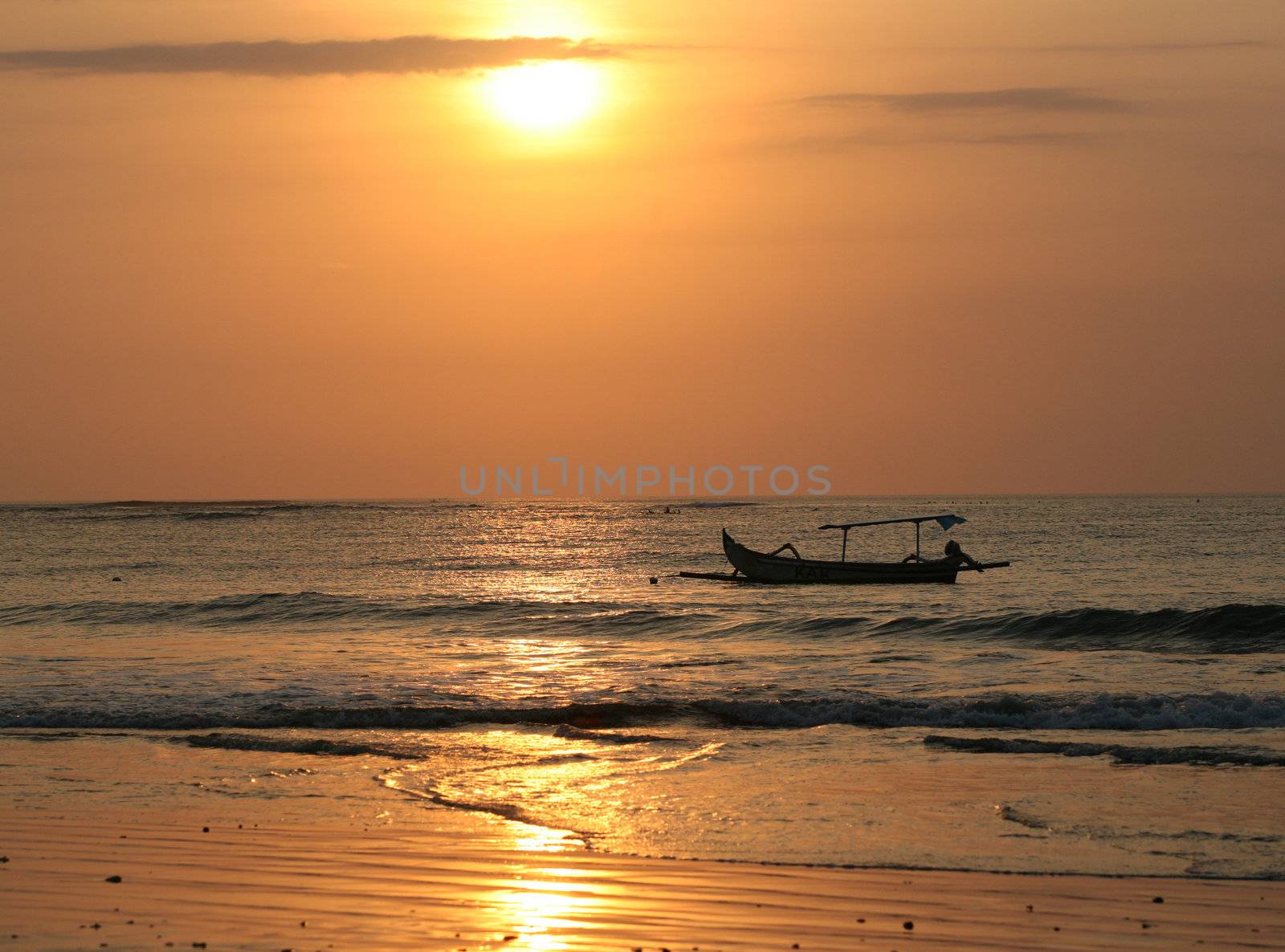 Drifting boat on a sunset. Coast of the Indian ocean. Bali