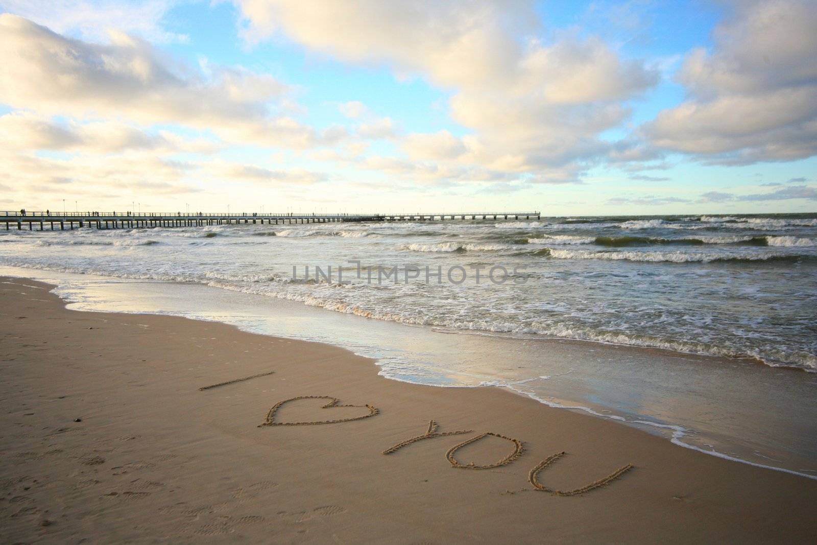 Words about love written on wet sand