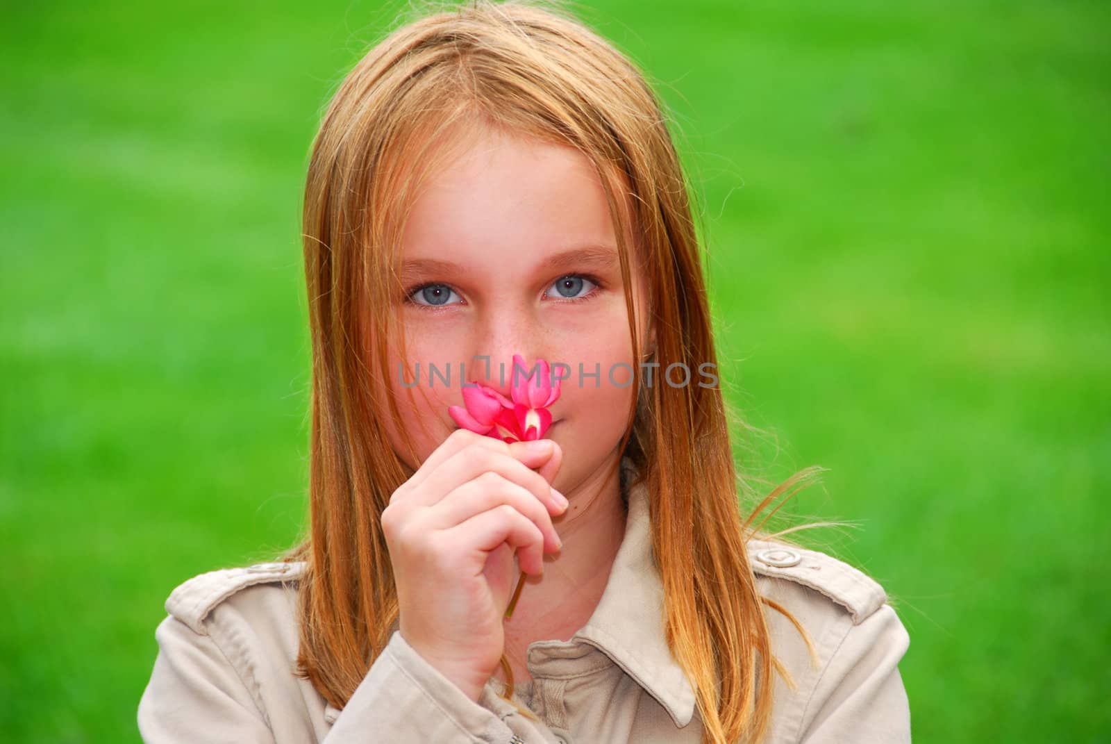 Young girl holding a pink flower in her hand