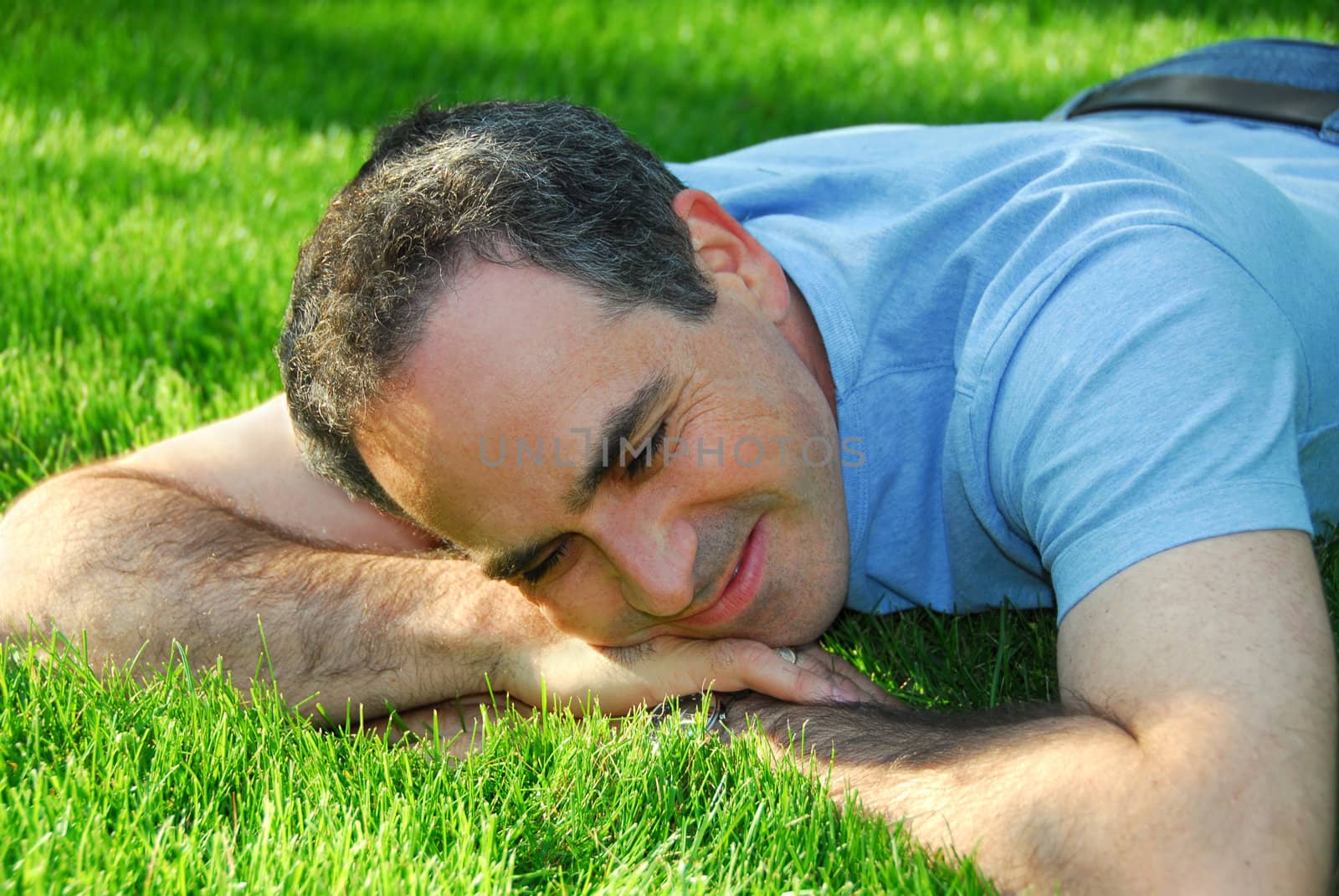 A man lying on green grass relaxing