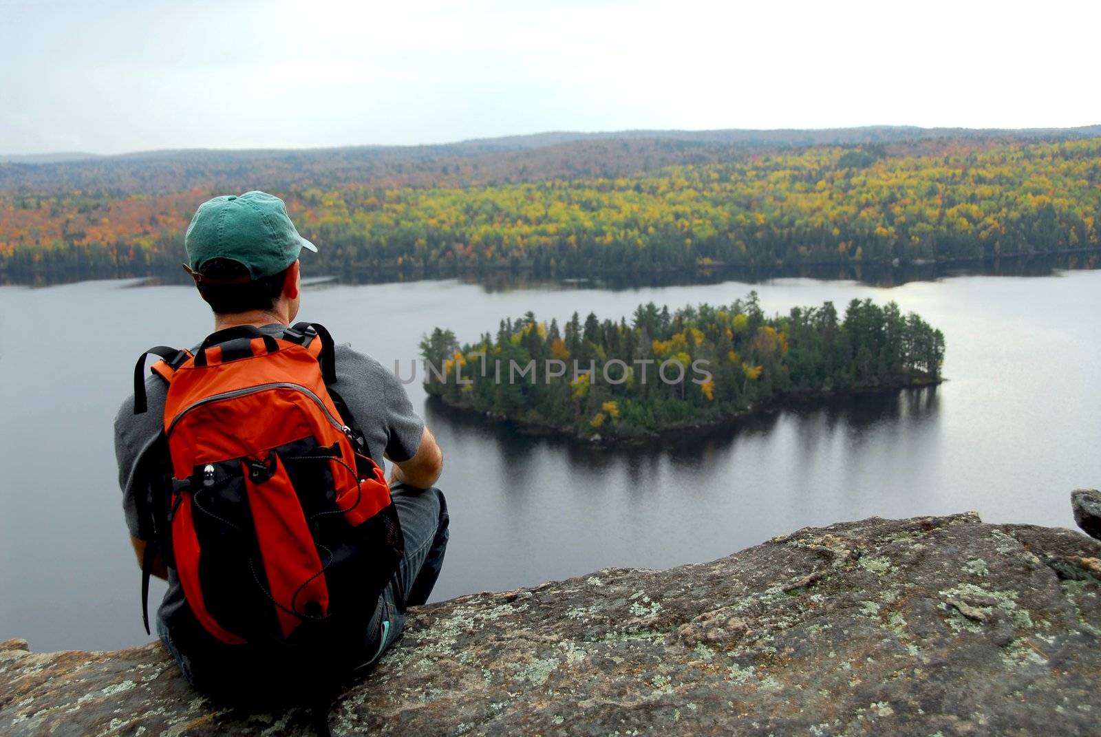 A hiker sitting on a cliff edge enjoying scenic view