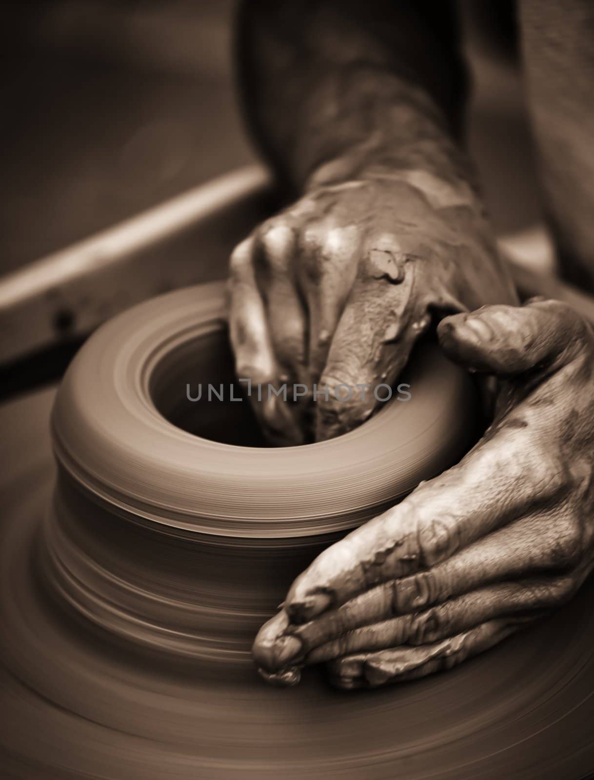 Hands working on pottery wheel by Lizard