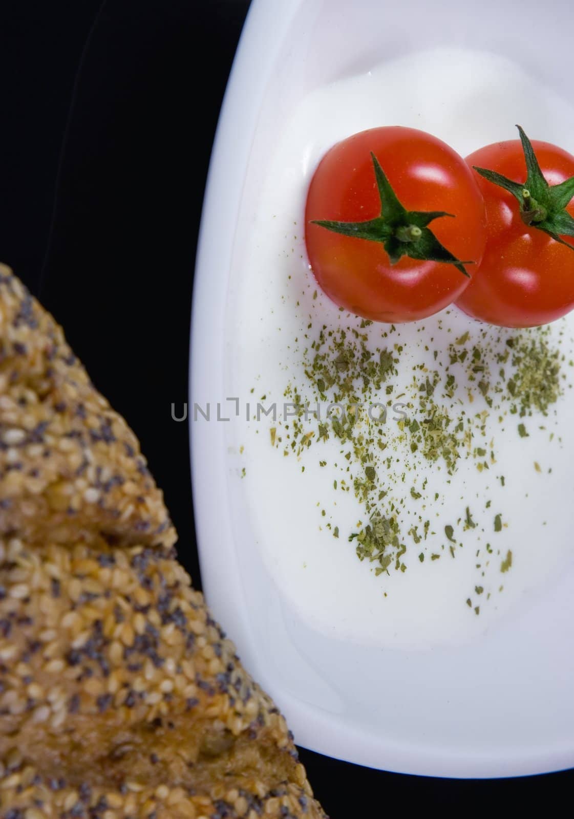 Creamy soup with tiny red tomatoes, close up photo