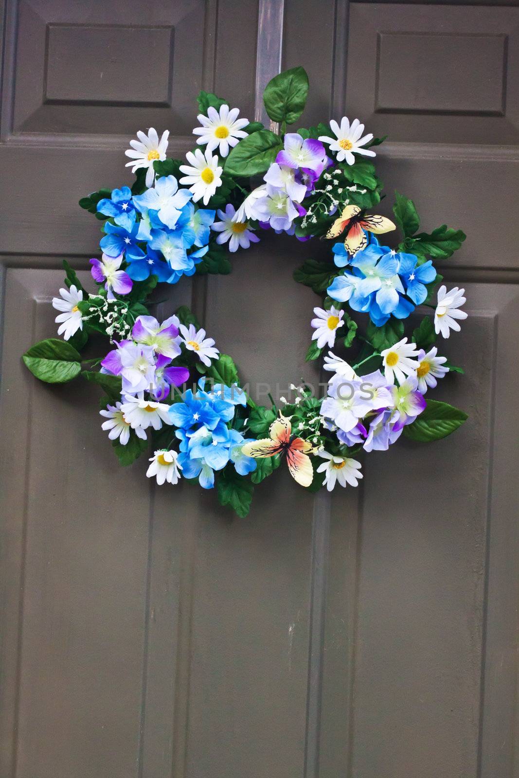 A different colored flowers door wreath  hanging on the door