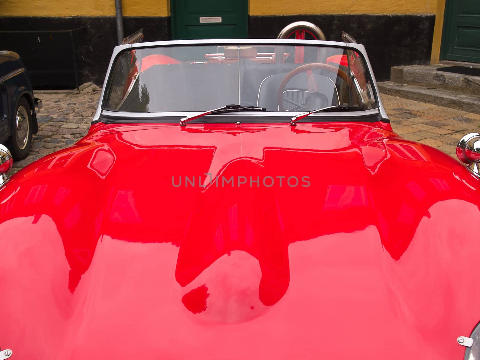 Details of a vintage classical European red sports car