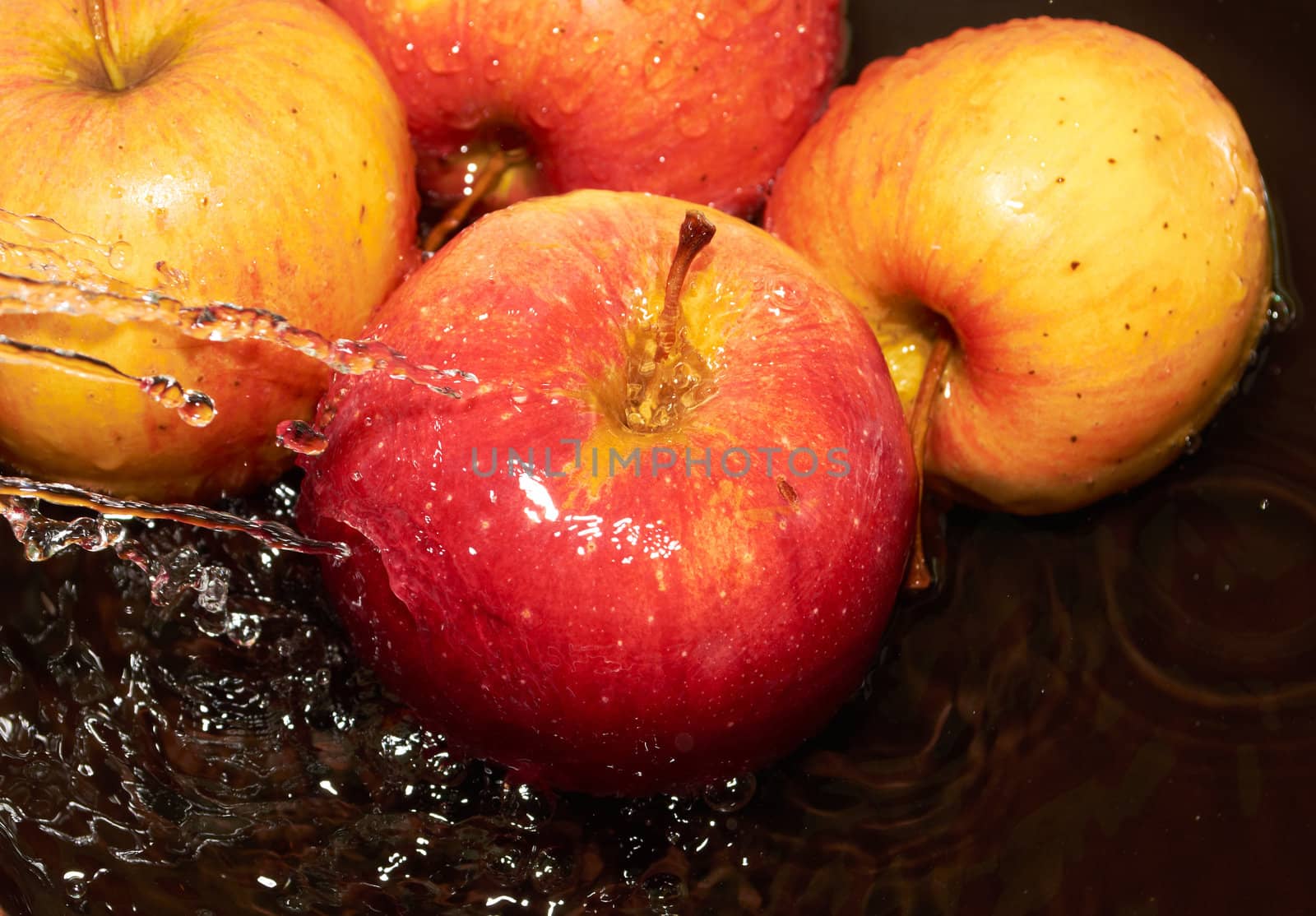 Ripe red apple is under the running water