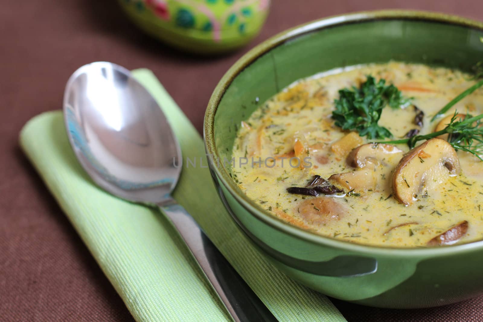 Mushroom soup in a green bowl with a spoon