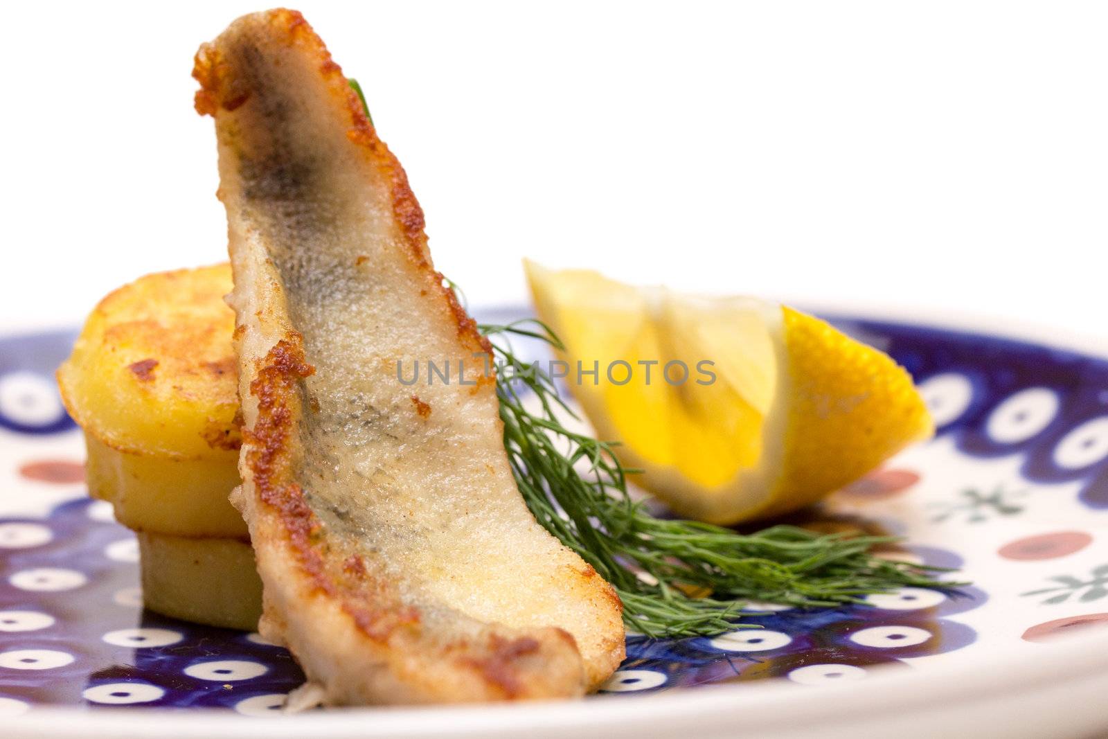 Perch filet with fried potatoes, lemon and dill