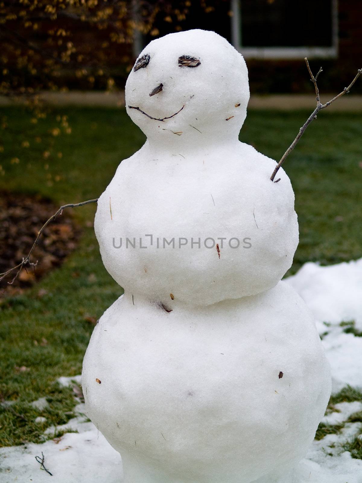 Snowman in the Front Yard of a House after a Little Snowfall