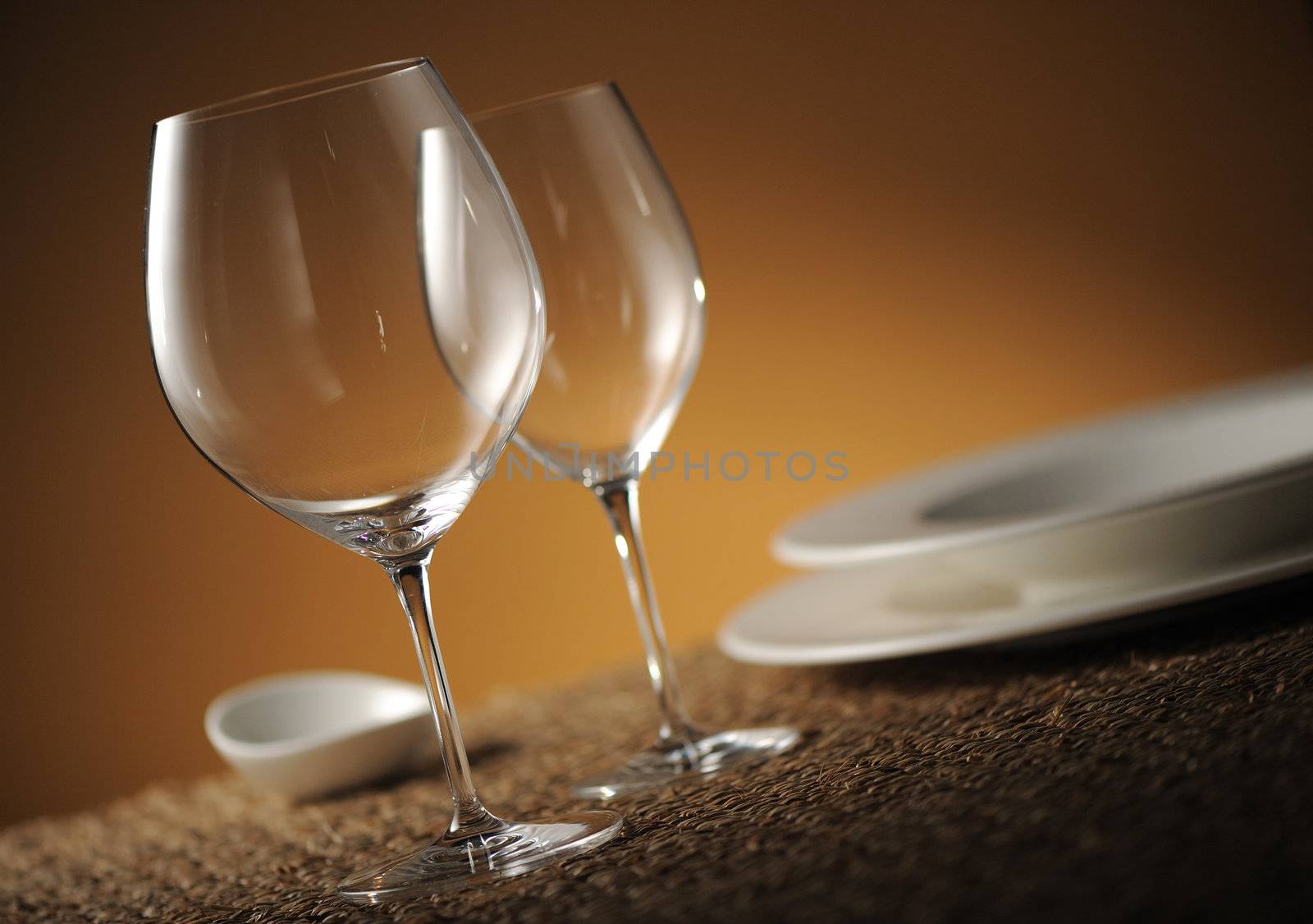 Dinner place setting with plates, glasses and cutlery shallow do by stokkete