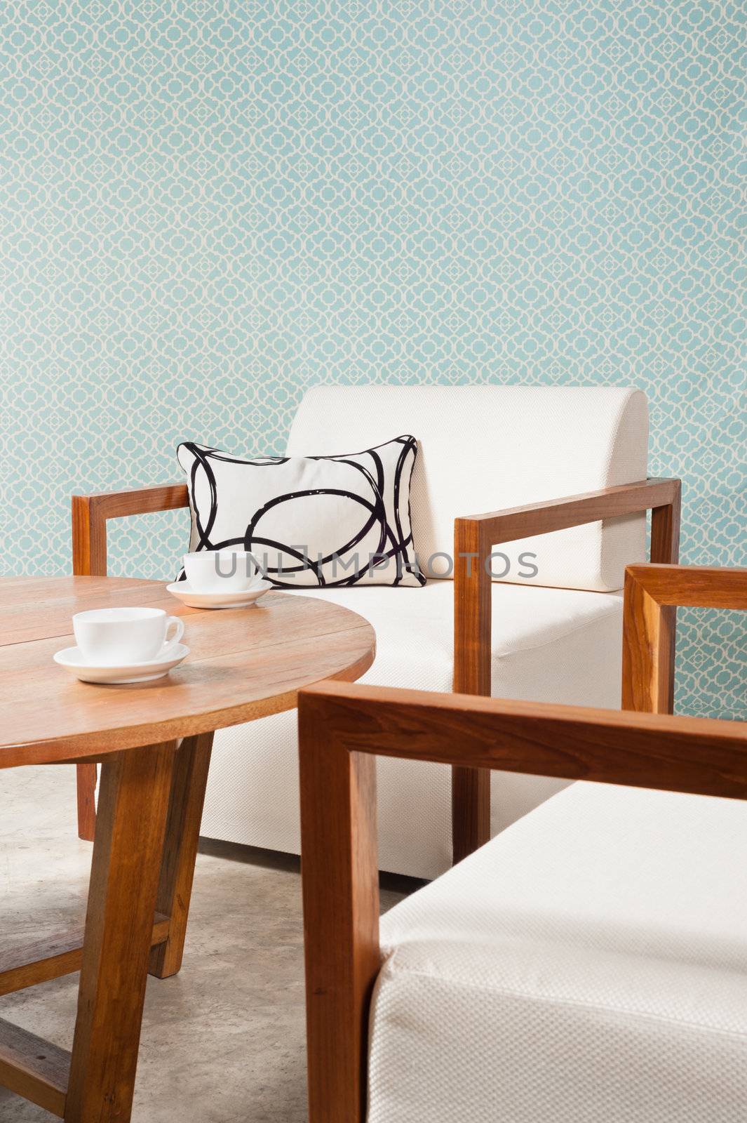 Brown white furniture in a living room and turquoise blue wallpaper