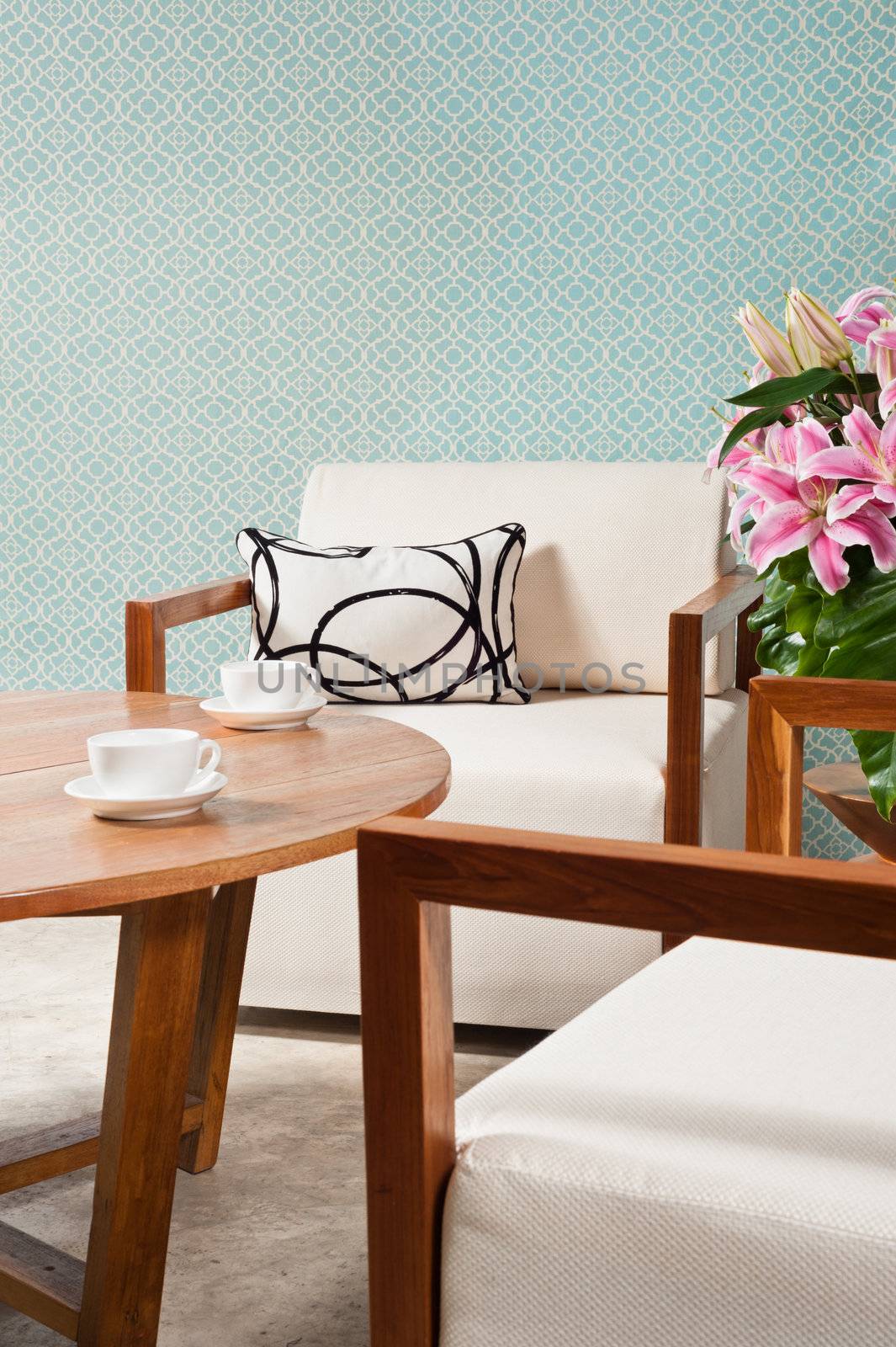 Brown white furniture in a living room and turquoise blue wallpaper