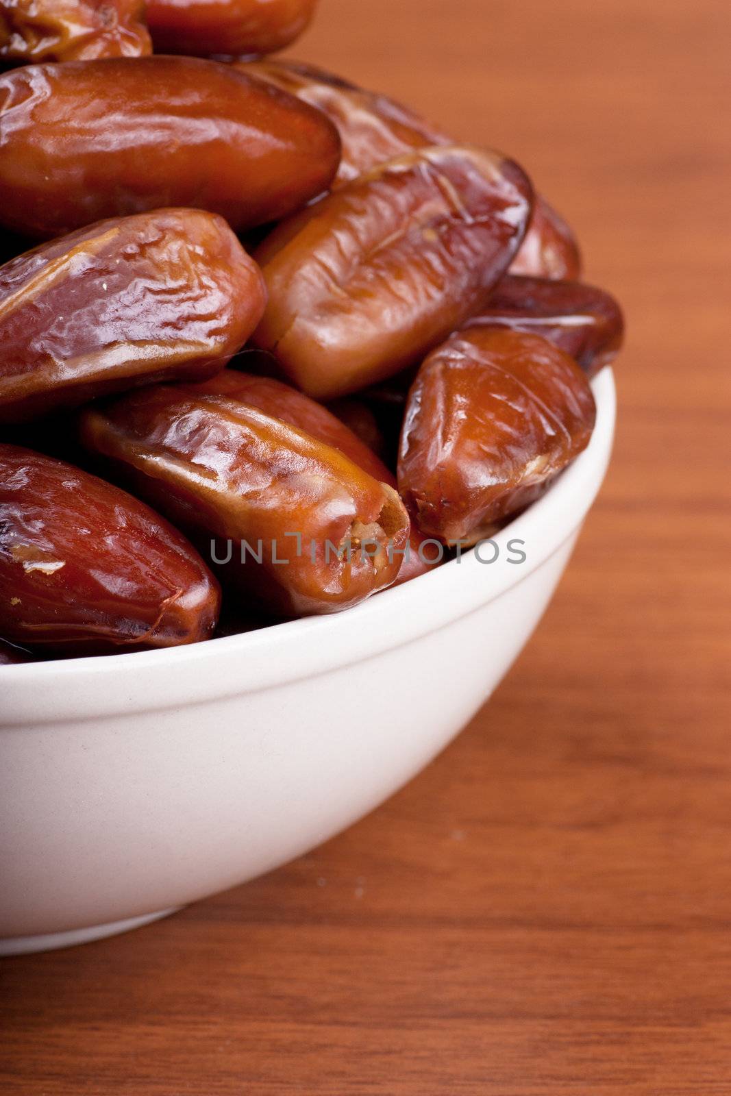 Sweet dates in a white bowl on a table