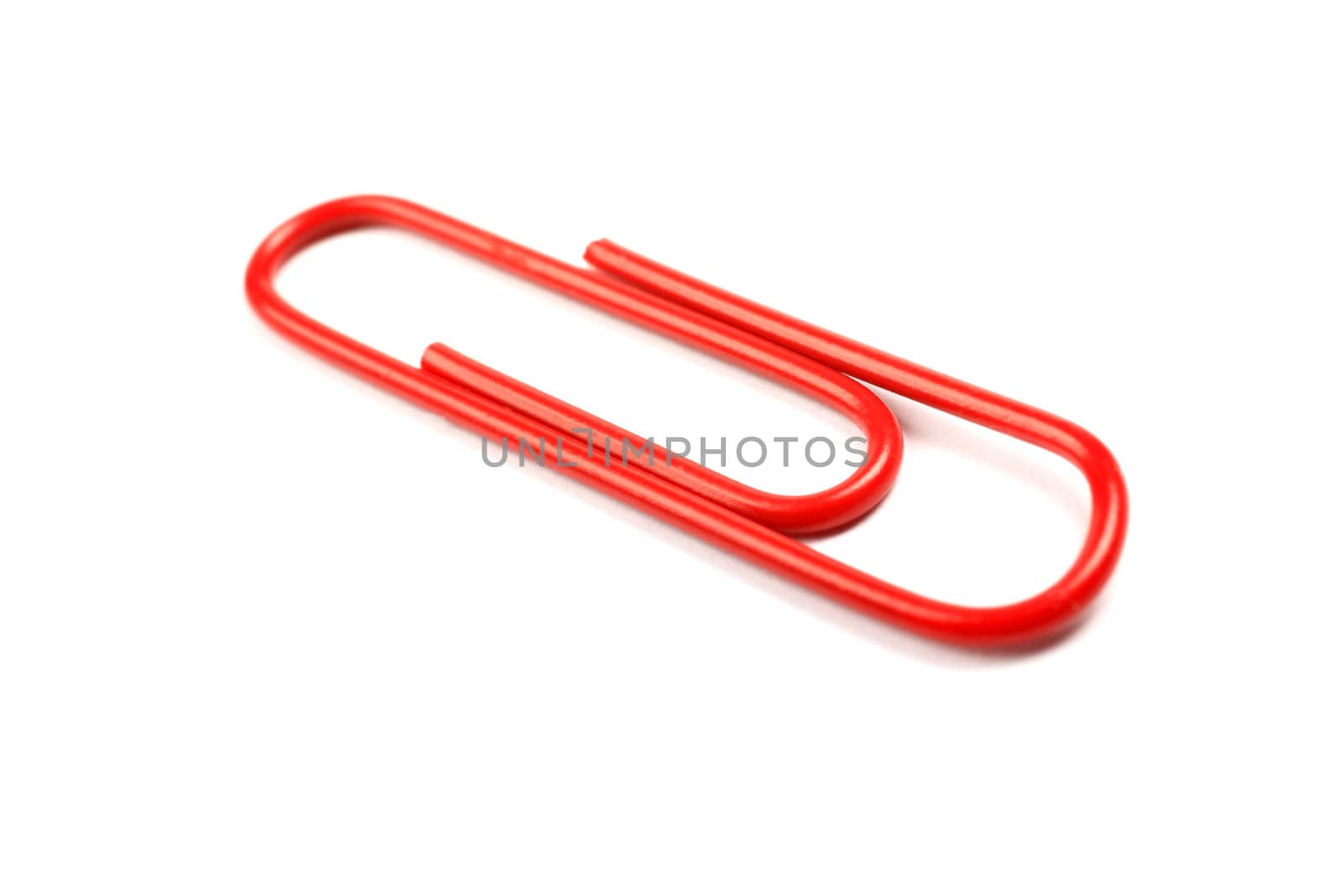 Macro of red paper clip isolated on white background. by borodaev