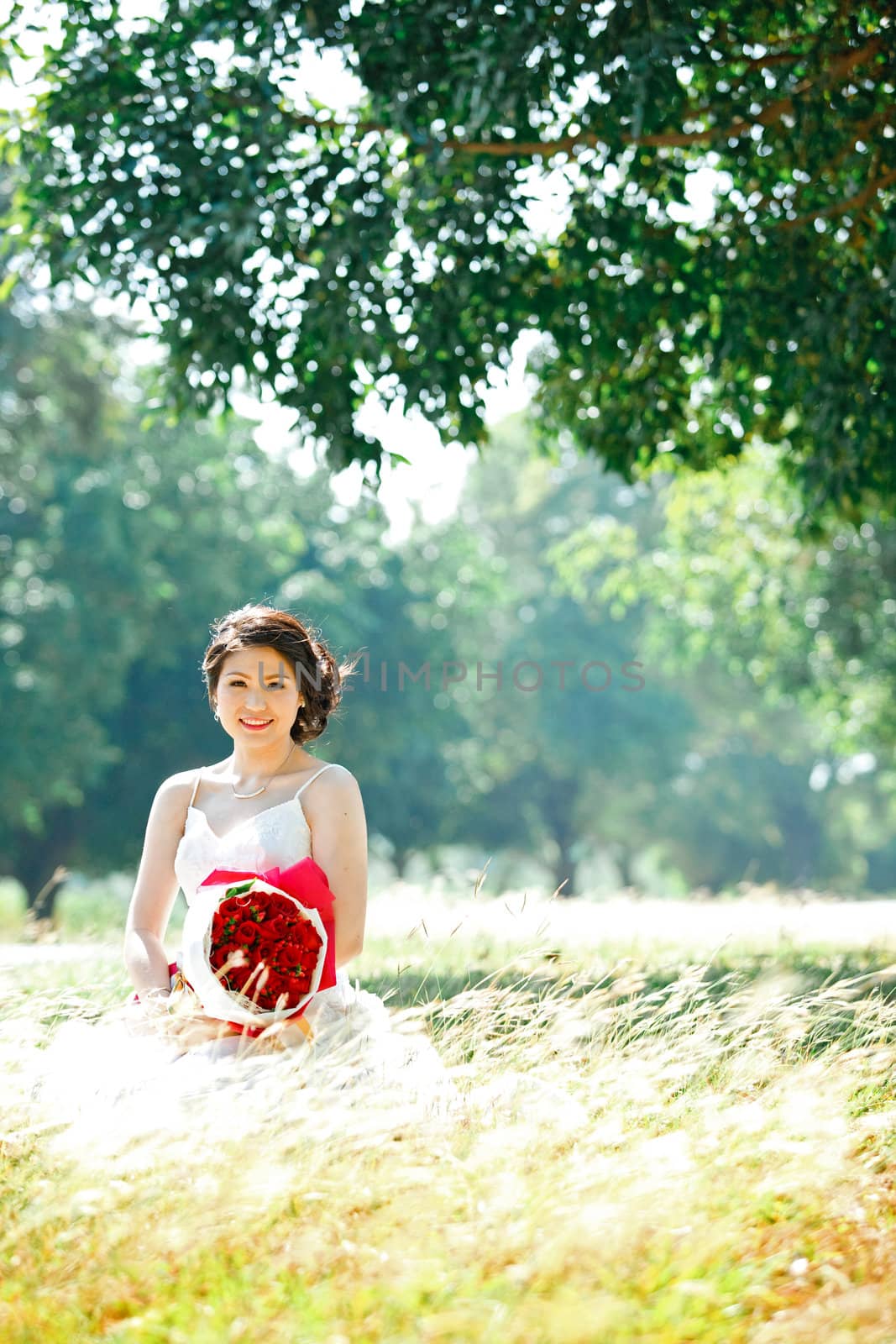 portrait of beautiful bride with rose bouquet on autumn meadows field