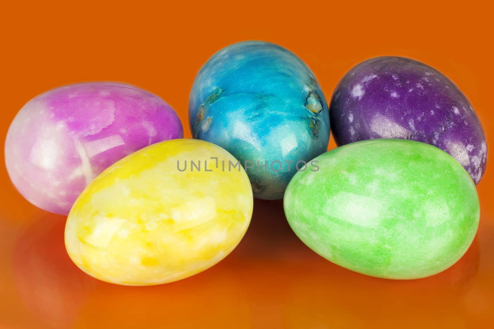 Easter eggs in different colors on an orange background
