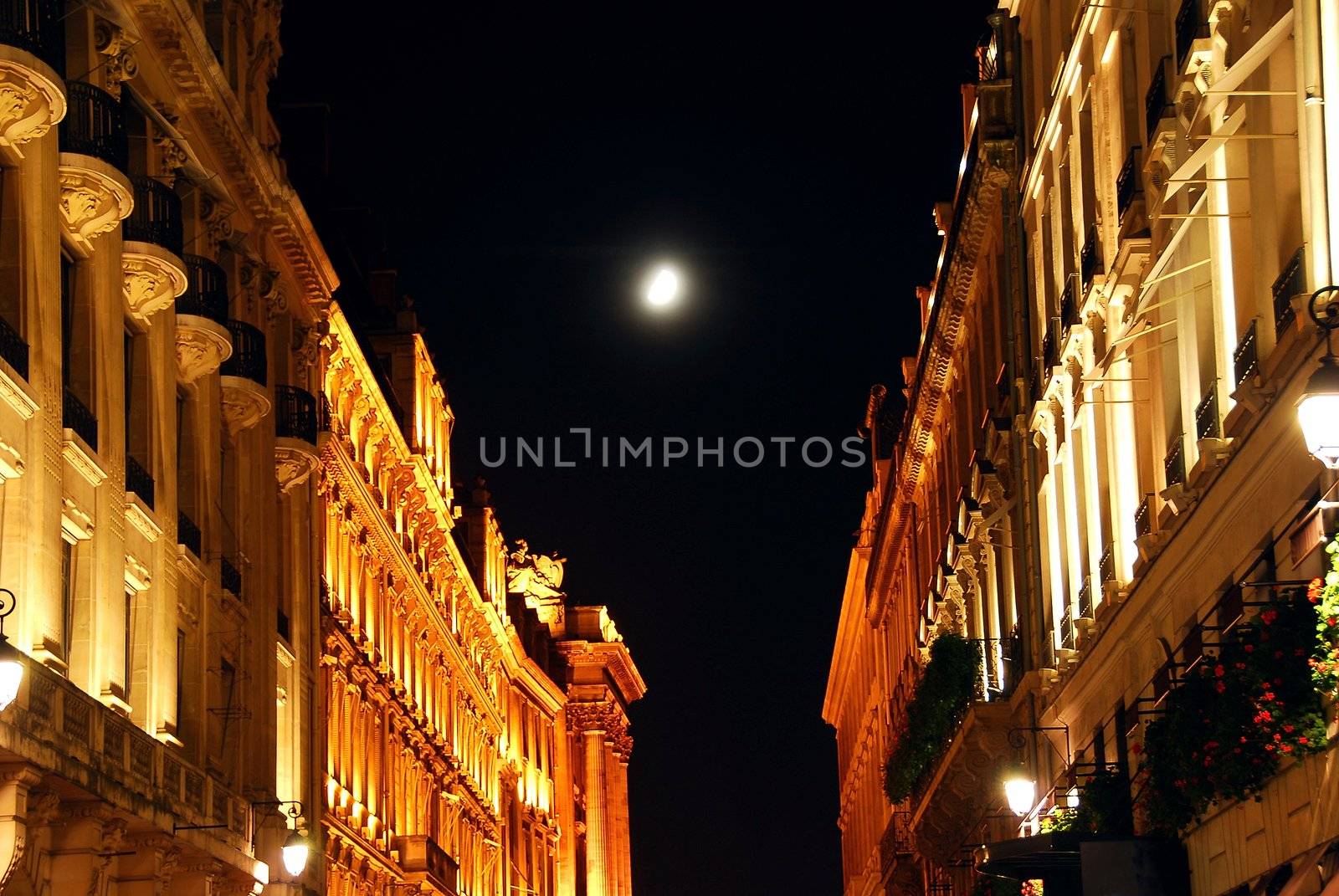 Illuminated street in Paris France at night with bright moon