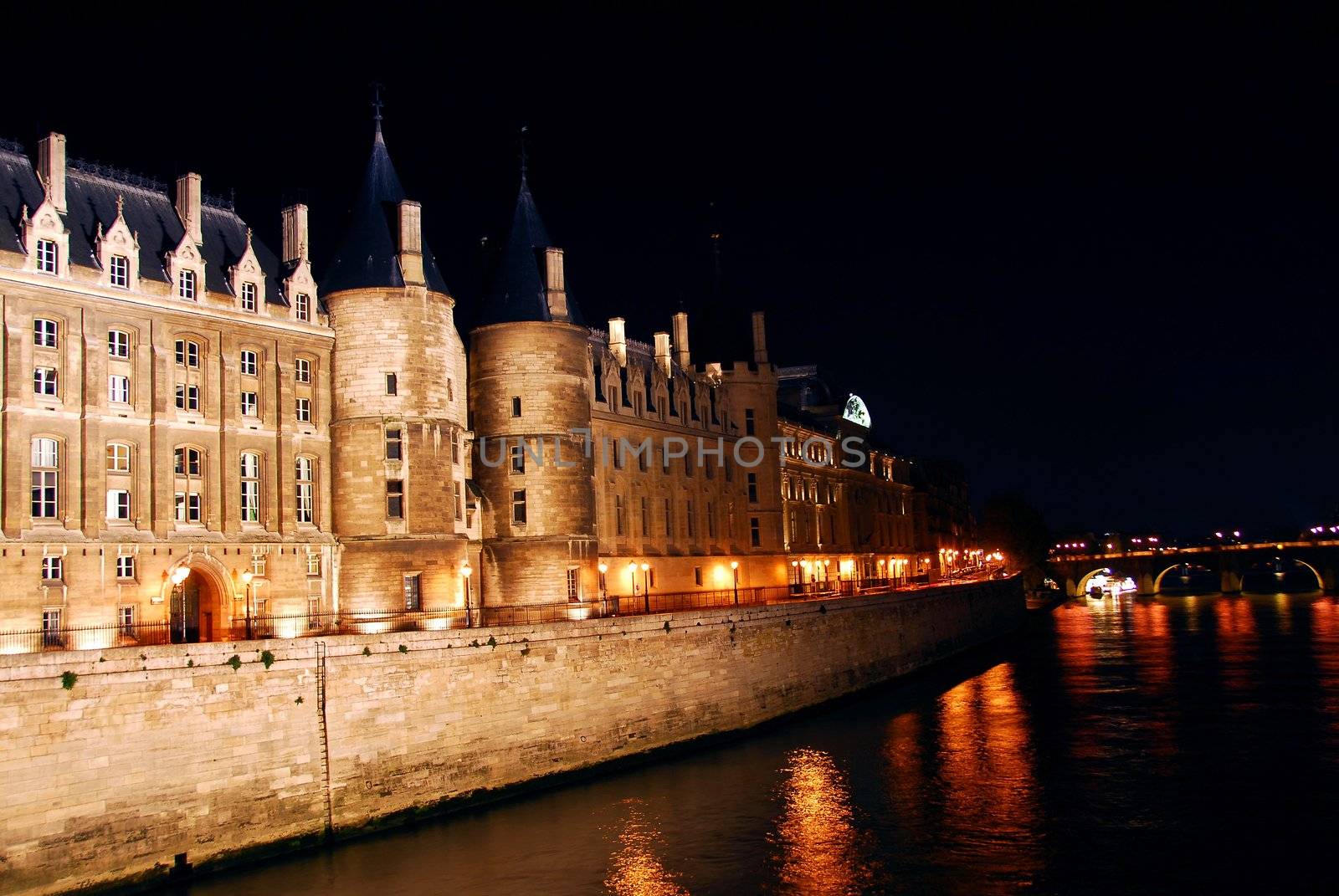 Bridges over Seine and Conciege in nighttime Paris France
