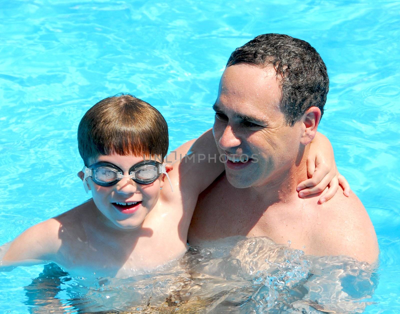Father and son having fun in a swimming pool