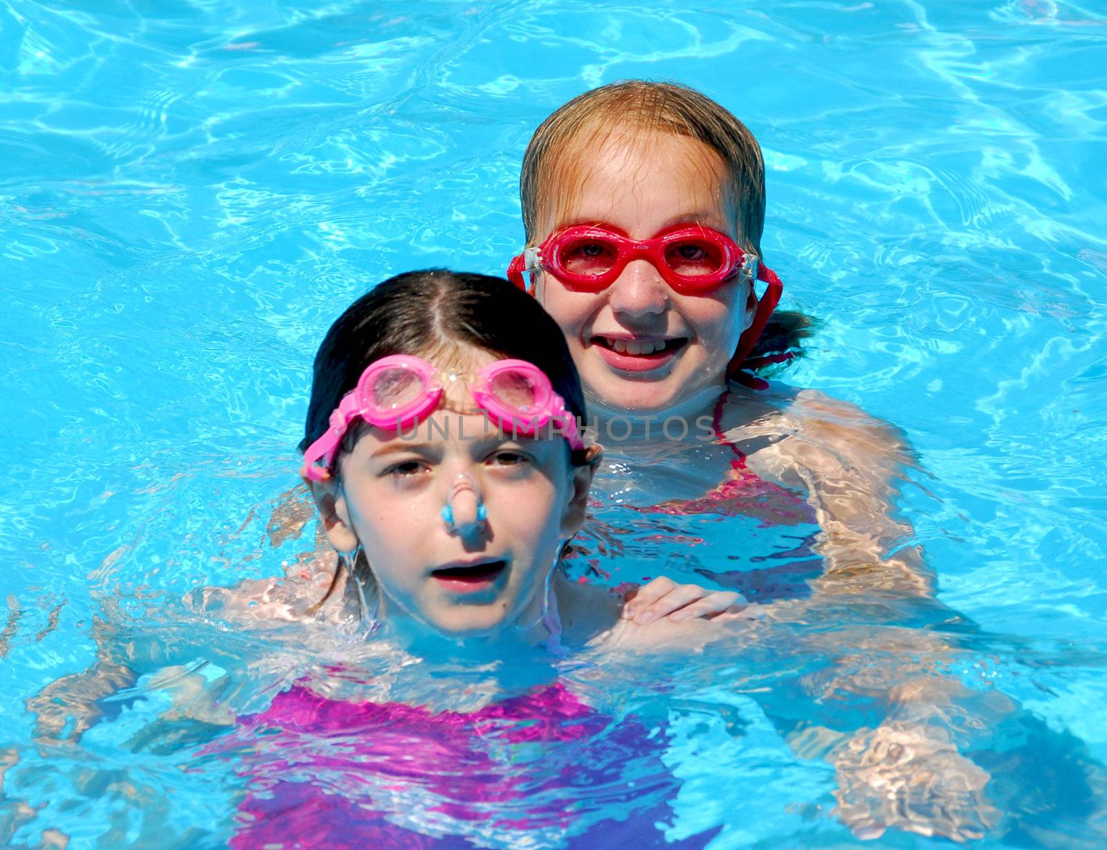 Two girls having fun in a swimming pool