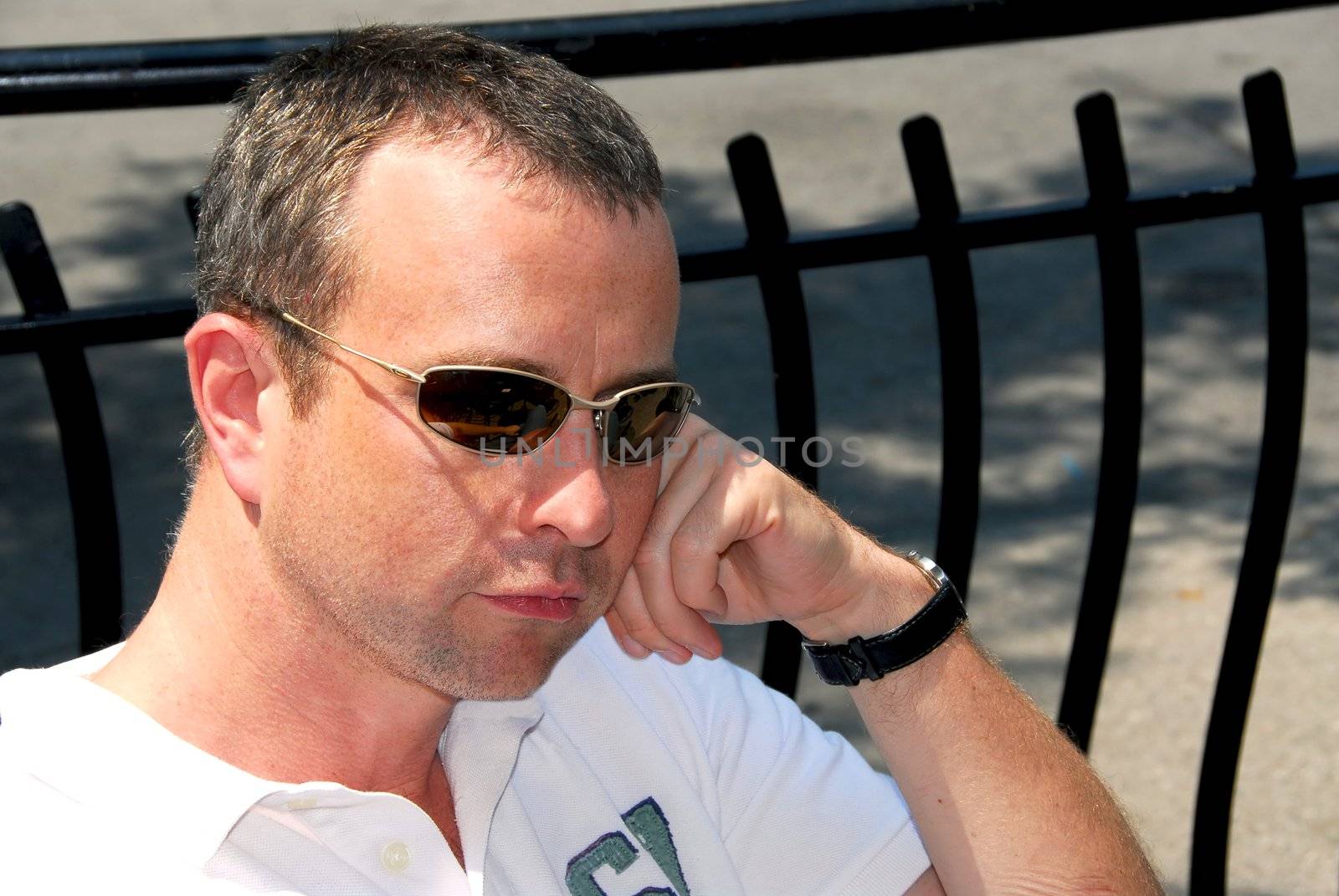 Portrait of a thoughtful man wearing sunglasses in outdoor cafe 