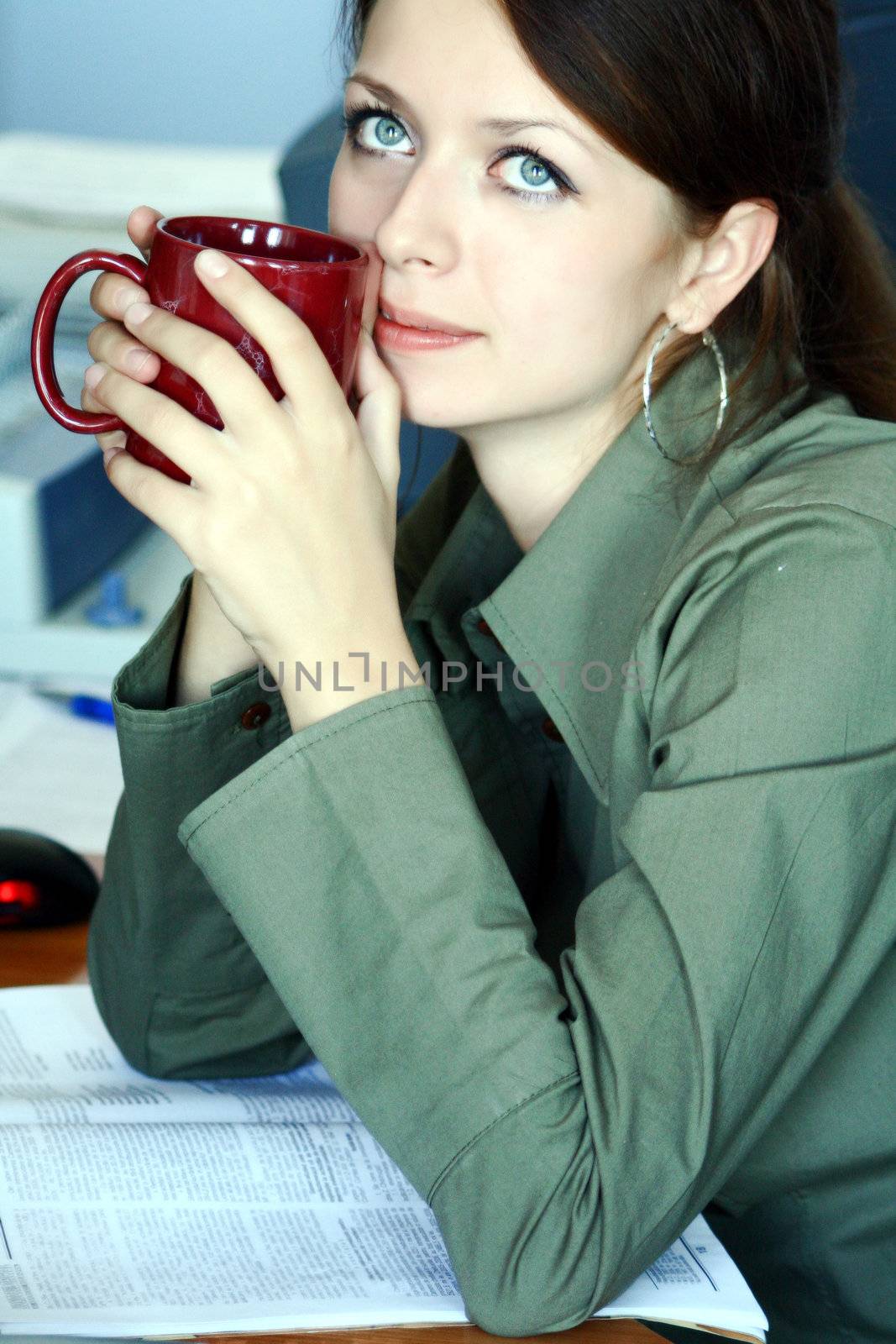 Girl sitting in the office, having coffee break