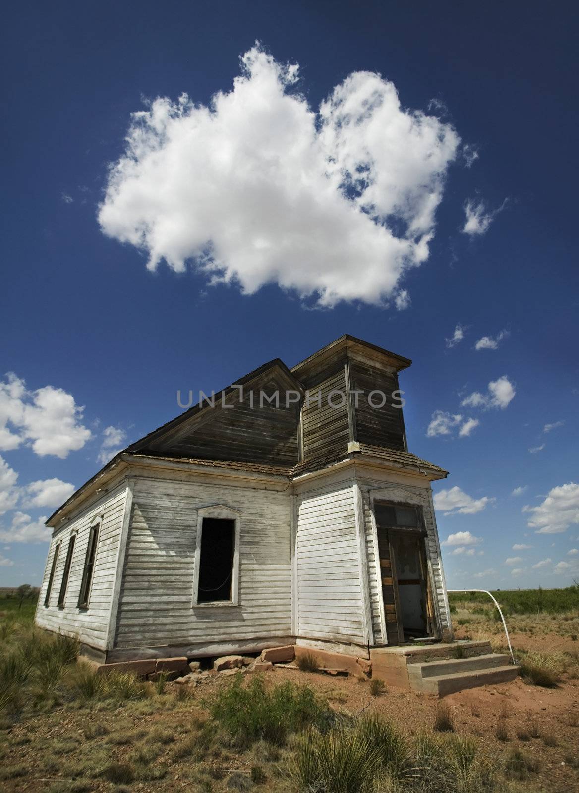 Abandoned and forgotten rural church against a deep blu sky. 