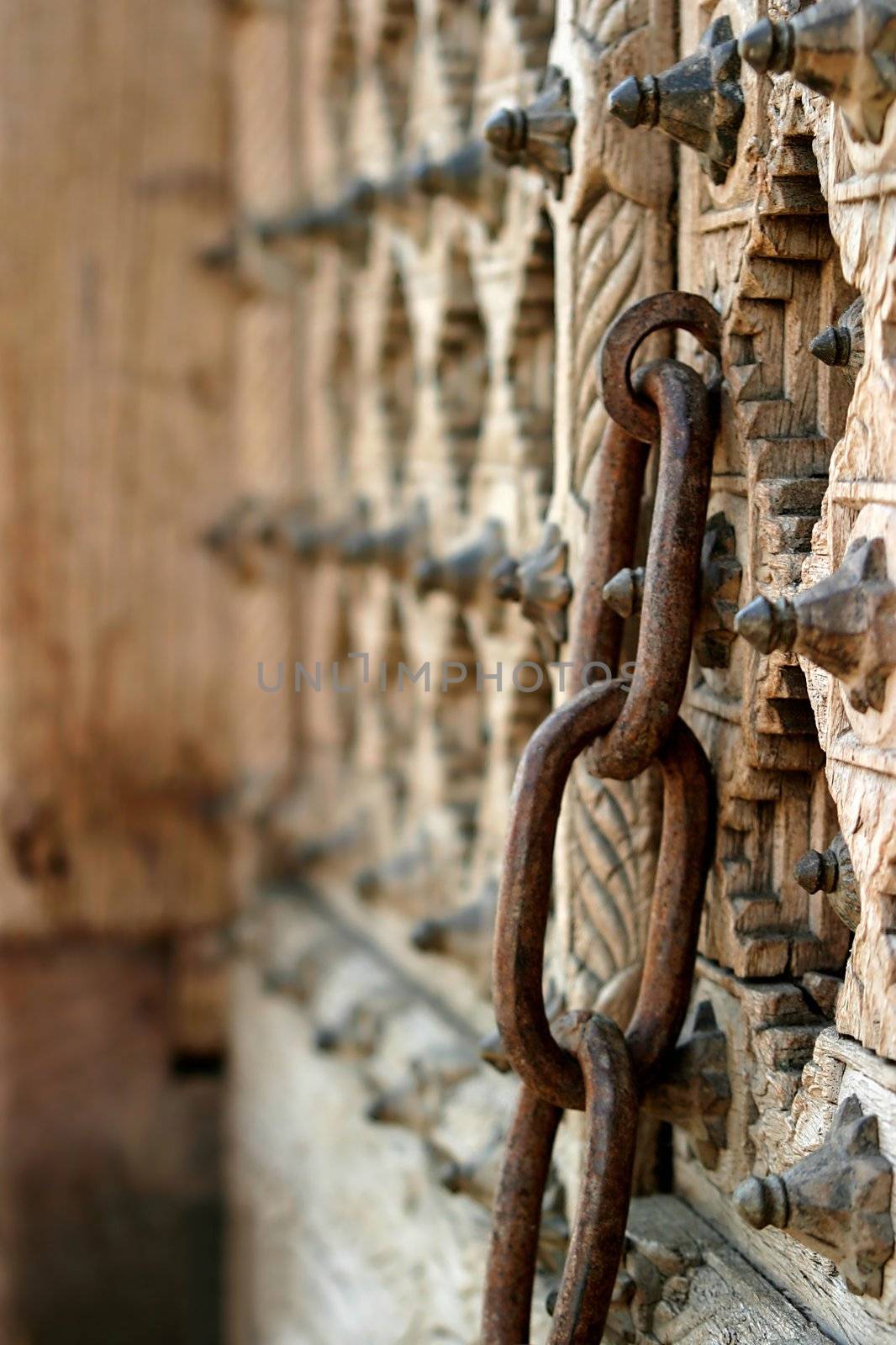 Rusty chain on an old wooden door.