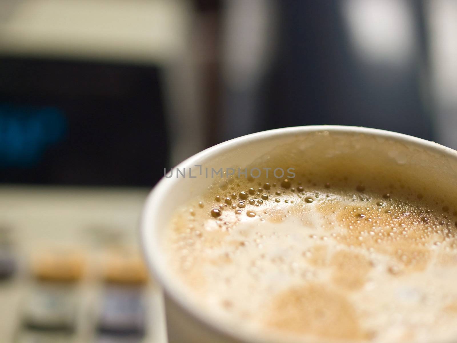 Cup of Coffee in a Paper Cup on a Office Desk