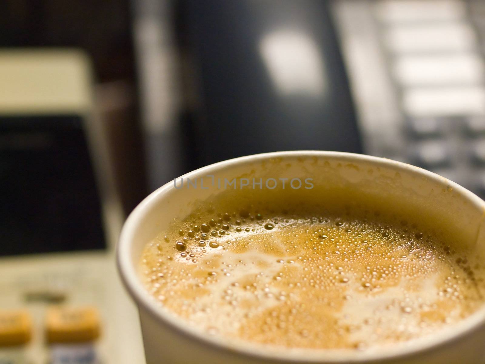 Cup of Coffee in a Paper Cup on a Office Desk