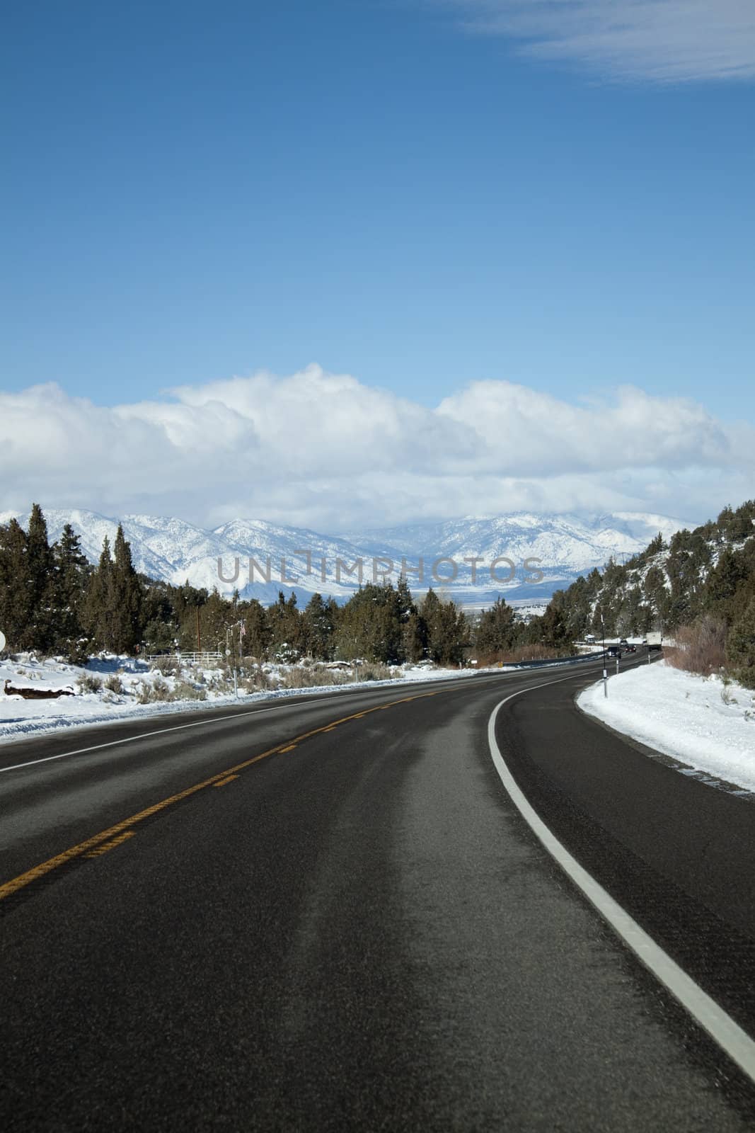 mountain range with an empty road and blue skies.