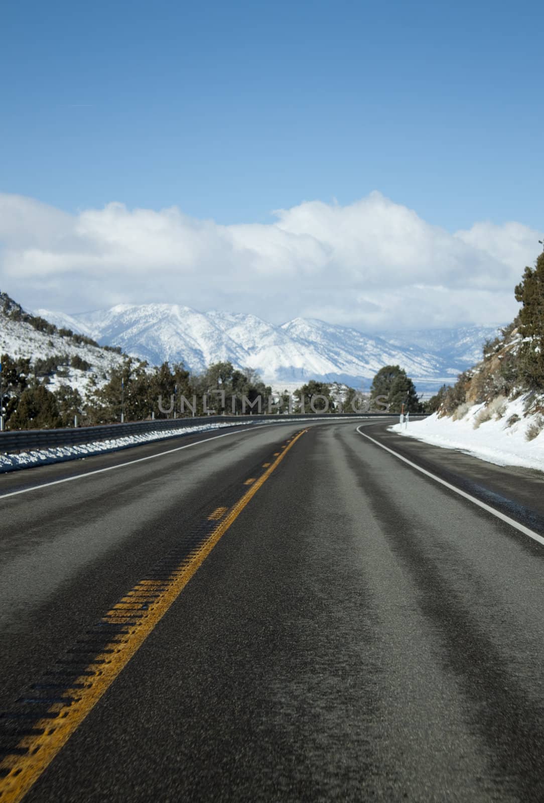 mountain range with an empty road and blue skies.